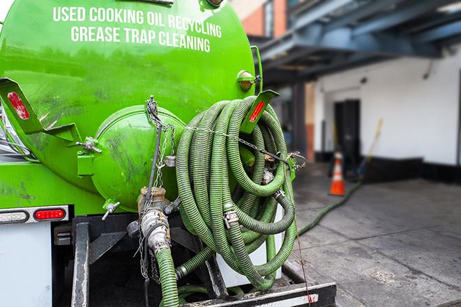 a grease trap being pumped by a sanitation technician in Centreville