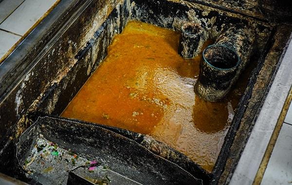 throughout grease trap cleaning, the trap is emptied, scraped, and washed to remove built-up grease and solids